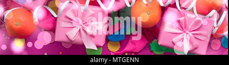Banner composizione decorativa tre caselle con doni di raso Bow arance coriandoli serpentina festa di compleanno. La vista dall'alto Foto Stock