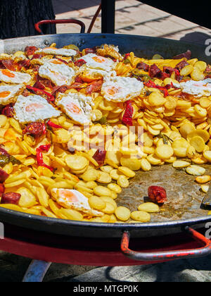 Uova di spagnolo. Uova fritte con chorizo, patate e peperoni in padella. Lo spagnolo street food. Foto Stock