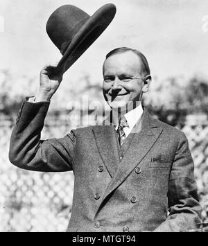 Calvin Coolidge, mezza lunghezza ritratto, in piedi, rivolto verso sinistra, il ribaltamento il suo cappello. Ottobre 1924 Foto Stock