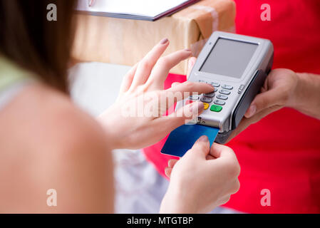 La consegna di pacchi essendo pagato con pos e carta di credito Foto Stock