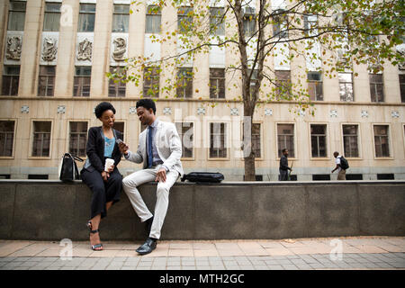 Uomo d'affari che mostra imprenditrice il suo telefono Foto Stock