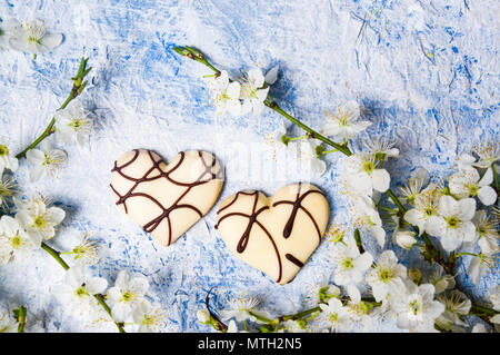 Bianco fiori lilla a forma di cuore i cookie su un tavolo Foto Stock