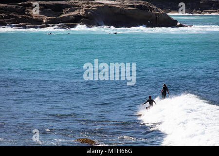 Surfisti che catturano le onde a Bronte Beach a Sydney, New South Wales, Australia Foto Stock