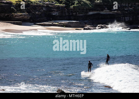 Surfisti che catturano le onde a Bronte Beach a Sydney, New South Wales, Australia Foto Stock