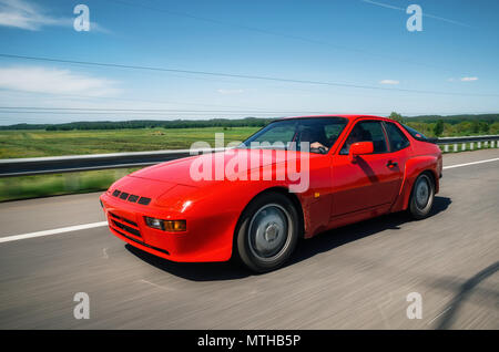 Minsk, Bielorussia - 26 Maggio 2018: Rosso vintage Porsche 944 auto sportiva accelerando lungo la strada con motion blur effetto. Foto Stock