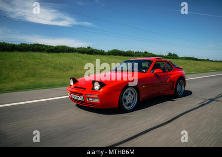 Minsk, Bielorussia - 26 Maggio 2018: Rosso vintage Porsche 944 auto sportiva accelerando lungo la strada con motion blur effetto. Foto Stock