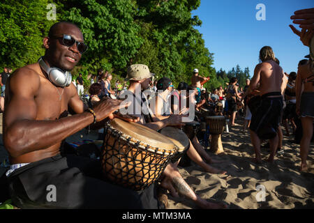 Terza Spiaggia, il centro cittadino di Vancouver, British Columbia, Canada - 22 Maggio 2018: Persone aventi il divertimento a un cerchio del tamburo evento durante una vibrante del tramonto. Foto Stock