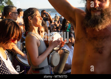 Terza Spiaggia, il centro cittadino di Vancouver, British Columbia, Canada - 22 Maggio 2018: Persone aventi il divertimento a un cerchio del tamburo evento durante una vibrante del tramonto. Foto Stock