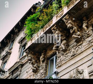 Facciata di edificio in Porta Venezia quartiere. Umanista ornamentali statue appeso alla parete. Architettura è presto 1900s natura ispirazione liberty, art-noveau style Foto Stock