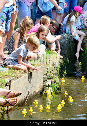 May Bank Holiday Duck gara nel villaggio allentati, Kent. I bambini guardare le anatre passare sulla Loose Brooks all'evento annuale. Foto Stock