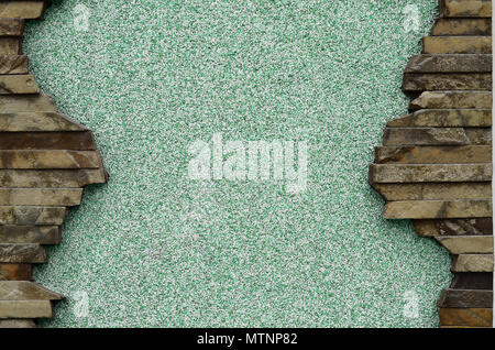 Intonacata e trattati verde parete in cemento con una bella cornice di forma rettangolare piatta pietre. Gli appalti per diapositive, presentazioni o tabelle con un hu Foto Stock