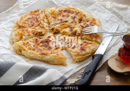 Formaggio a fette la pasta sulla tavola, accanto al tè turco. Foto Stock