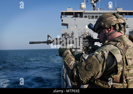 Il personale Sgt. Christopher Lewis, un Chaplin Assistant con la 316supporto comando (Expeditionary), incendi la m4 carbine durante un'acqua Gunnery esercizio di tiro a bordo del supporto logistico Nave - 5 (LSV-5) "MG Charles P. lordo" nel Golfo Arabico, Gennaio 24, 2017. (U.S. Foto dell'esercito da Staff Sgt. Dalton Smith) Foto Stock