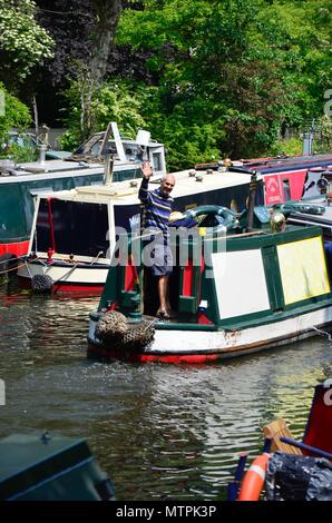 Un uomo sventolare da un battello del canale sul Regents Canal in Little Venice, Londra, Inghilterra Foto Stock