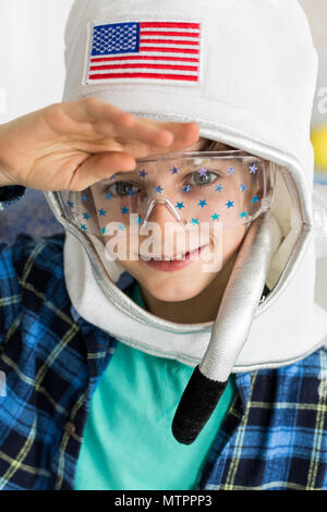 Inquadratura di un piccolo ragazzo che indossa un giocattolo casco di spazio Foto Stock