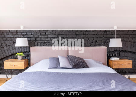 White piumone e cuscini sul letto con girato posti di legno nella camera da  letto del paese con nero+crema tende a motivi geometrici Foto stock - Alamy