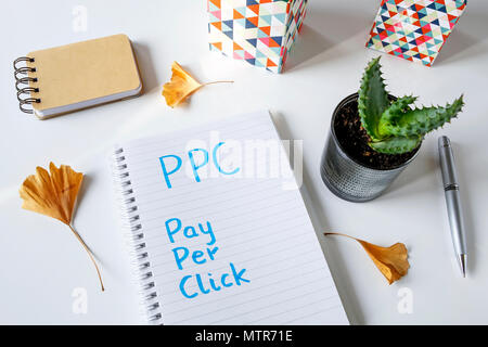 PPC Pay Per Click scritto in un notebook sul tavolo bianco Foto Stock