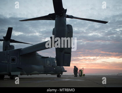 Equipaggio capi dal 352d per le operazioni speciali squadrone di manutenzione di comunicare con un equipaggio dal 7 Special Operations Squadron come si preparano per l'avvio un CV-22 Osprey Gen 17, 2017 sulla RAF Mildenhall, Inghilterra. Il personale di manutenzione e di equipaggio collaborano strettamente prima e dopo ogni volo per mantenere il CV-22 in grado di portare una combinazione di velocità e verticale - capacità di sollevamento non soddisfatti da qualsiasi altro esistente-fisso o rotante-piattaforma di ala. (U.S. Air Force Photo da 1 Lt Chris Sullivan) Foto Stock