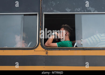 Un uomo cubano che viaggiano su un autobus pubblico a l'Avana. Foto Stock