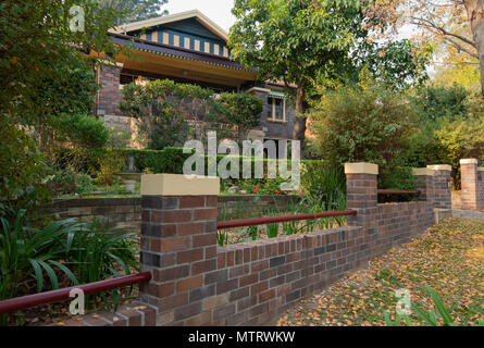 Un 1928 tetto di tegole e mattoni doppi, con facciata a timpano, California Bungalow a casa con una corrispondente facciata di mattoni recinto sul Sydney north shore nel NSW Australia Foto Stock
