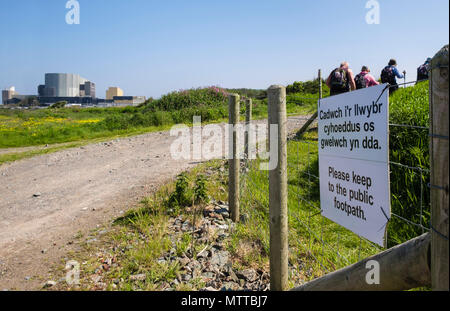 Cartello bilingue su Anglesey Coastal path reinstradato intorno a Wylfa centrale nucleare con gli escursionisti a piedi nel 2018. Cemaes Isola di Anglesey nel Galles REGNO UNITO Foto Stock