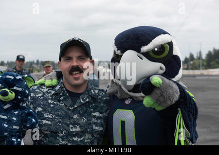 180525-N-EF115-050 BREMERTON, nello Stato di Washington (25 maggio 2018) Da elettricista, mate 1. Classe Giosuè Henry, da Gilchrist, Oregon, pone con Seattle Seahawks mascot, Blitz, a bordo della portaerei USS John C. Stennis (CVN 74). La Seattle Seahawks squadra di calcio e di mare galloni cheerleaders tenuto un apprezzamento militare evento a bordo per incontrare e parlare con i marinai. John C. Stennis è pier-lato dopo il ritorno a homeport dopo il completamento di un periodo di sette settimane in corso in cui l'equipaggio della nave completata TSTA/FEP precoce e Carrier Strike Gruppo 3 Gruppo Vela in preparazione per la sua prossima distribuzione programmata. (U.S. Na Foto Stock