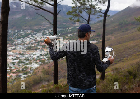 L'uomo operando un flying drone in campagna Foto Stock