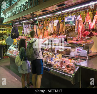 Coppia giovane shopping presso un cibo in stallo Mercat de la Boqueria, Barcellona, Catalunya, Spagna. Foto Stock