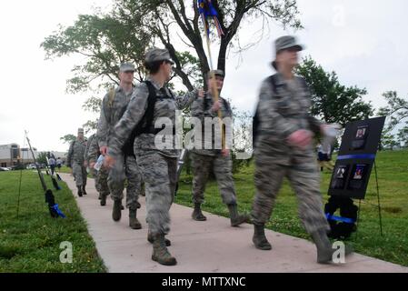 Team membri McConnell a piedi passato cerimoniale di ghirlande Maggio 16, 2018 a McConnell Air Force Base, Kansas, 16 maggio 2018. Ciascuna corona è stata posta in onore di aviatori che morì nel 2015 durante un motociclo kamikaze attaccano a Bagram Airfield e per due che sono passati in un C-130J Hercules crash vicino a Jalalabad, in Afghanistan nel 2016. (U.S. Air Force foto di Airman 1. Classe Alan Ricker). () Foto Stock