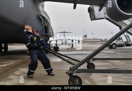 Il personale Sgt. Zachary Rodewig, 721st Manutenzione aeromobili squadrone C-5 Galaxy capo equipaggio, tira una piattaforma di manutenzione fino a un C-5 a Ramstein Air Base, Germania, gennaio 24, 2017. Rodewig e altri 721st AMXS aviatori riunite il piano al suo posto, bloccate le ruote, inserito in un generatore, controllare la pressione dei pneumatici, riforniti di olio, e rifornimento di carburante il piano. La 721st AMXS ispeziona, riparazioni e servizi tutti i C-17 Globemaster III e C-5 aerei che arrivano attraverso Ramstein. (U.S. Air Force foto di Senior Airman Tryphena Mayhugh) Foto Stock