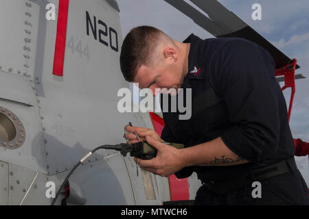170130-N-WV703-017 CHANGI base navale, Singapore (GEN. 30, 2017) Aviation da elettricista, Mate 2a classe Mark Kelly, assegnato all'elicottero Combat Squadron (HSC 23) Det. 5, da Dalton, Ga., esegue i test operativi su un MQ-8B Fire Scout dei velivoli senza pilota a bordo del sistema Littoral Combat Ship USS Coronado (LCS 4). Attualmente su una distribuzione di rotazione a sostegno del ribilanciamento Asia-Pacifico, Coronado è un veloce ed agile nave da guerra fatta su misura per pattugliare le acque della regione marine e lavoro carena e scafo con partner marine, fornendo 7 flotta con le funzionalità flessibili di cui ha bisogno ora e in futuro. Foto Stock