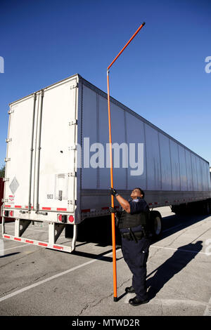 Un ufficiale con gli Stati Uniti Delle dogane e della protezione delle frontiere ufficio di operazioni su campo utilizza un bastone di misura per garantire il gioco corretto nel corso delle ispezioni dei veicoli commerciali un arrivano a NRG Stadium in preparazione per il Super Bowl 51 a Houston, Texas, Gennaio 30, 2017. I veicoli sono scansionati da raggi X prima dell'entrata in stadio principale strutture. Stati Uniti Delle dogane e della protezione delle frontiere Foto di Glenn Fawcett Foto Stock