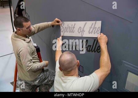 Tech. Sgt. Bryan Swift e Tech. Sgt. Juston Ocheltree, manutentori con la 130Airlift Wing, applicare lo "spirito del Kanawha Valley" decalcomania per un C-130H, 25 aprile 2017, a McLaughlin Air National Guard Base, Charleston, W.Va. Le decalcomanie e sono adesivi riapplicato per un aeromobile dopo che esso è stato ristrutturato e verniciato. L'unità dedicata questo velivolo per la comunità nei dintorni di Charleston in onore del loro sostegno ai 130AW. Foto Stock