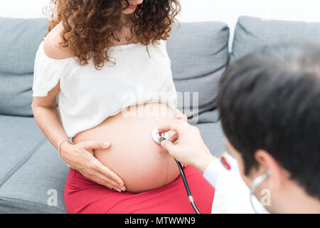 Medico visita una donna in stato di gravidanza Foto Stock