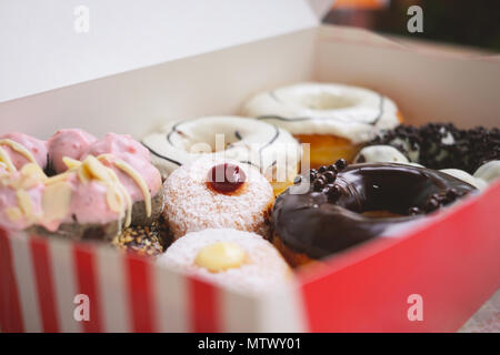 Un assortimento di vari di ciambelle con crema e vetrate in polvere Foto Stock