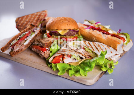 Fast food con piastra burger hot dog panini e wrap di pollo Foto Stock