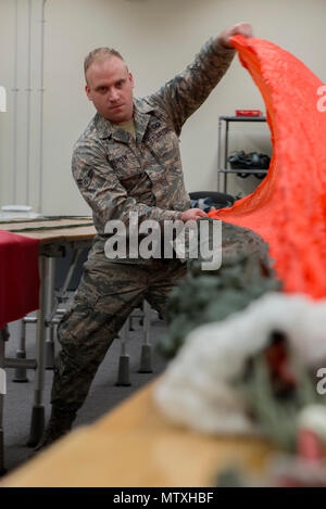 Airman 1. Classe Brent T. Spencer, 374 Operations Support Squadron equipaggi di volo volo apparecchiature apprendista, pre-pack di un paracadute tettoia gen. 31, 2017 a Yokota Air Base, Giappone. Il volo AFE è responsabile per la riparazione, imballaggio, e tutto intorno la manutenzione dei paracadute utilizzati da equipaggi e sopravvivenza, evasione, la resistenza e la fuga degli specialisti. (U.S. Air Force foto di Airman 1. Classe Donald Hudson) Foto Stock