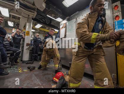 170131-N-CS953-002 Mar Arabico (GEN. 31, 2016) francese Marine Nationale Quartermaster 2a classe Adrienne Hennuyer gare danno il controllo vigile del fuoco Gregorio Desilva a mettere su un firefight ensemble durante l'esercizio Unified Trident 17 attraversare il ponte della formazione a bordo del Arleigh Burke-class guidato-missile destroyer USS Mahan (DDG 72). Unified Trident è un multilaterale esercizio marittimo con gli Stati Uniti Navy, Royal Navy, Australian Royal Navy e francese Marine Nationale per migliorare la mutua capacità, migliorare la tattica di competenza e rafforzare i partenariati nel garantire il libero flusso del commercio e della libertà di nav Foto Stock