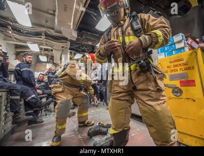 170131-N-CS953-004 Mar Arabico (GEN. 31, 2016) francese Marine Nationale quarto master-2a classe Adrienne Hennuyer gare danno il controllo vigile del fuoco Gregorio Desilva a mettere su un firefight ensemble durante l'esercizio Unified Trident 17 attraversare il ponte della formazione a bordo del Arleigh Burke-class guidato-missile destroyer USS Mahan (DDG 72). Unified Trident è un multilaterale esercizio marittimo con gli Stati Uniti Navy, Royal Navy, Australian Royal Navy e francese Marine Nationale per essere a migliorare la mutua capacità migliorano la competenza tattica e rafforzare i partenariati nel garantire il libero flusso del commercio e della libertà o Foto Stock