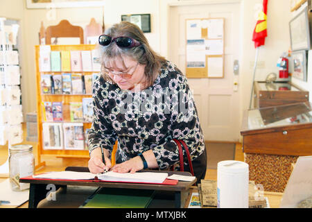 Vicki Mullen, moglie del Brig. Gen. William F. Mullen III, centro di combattimento comandante generale, firma il libro degli ospiti presso il vecchio Schoolhouse Museum di ventinove Palms, California, Gennaio 31, 2017. Il Mullens hanno visitato la struttura con Sgt. Il Mag. Michael J. Hendges, centro di combattimento Sergente Maggiore; Cpl. Ben Mills, driver; Jim Ricker, centro di combattimento assistente capo del personale per il governo e gli affari esterni; e Kristina Becker, combattere Centro Affari esterni Direttore. (Gazzetta Marine Corps Foto di Kelly O'Sullivan/rilasciato) Foto Stock