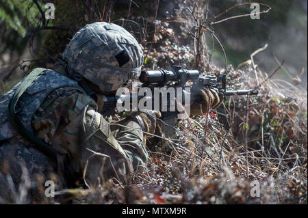 Un paracadutista assegnato al plotone Scout, sede e Sede Società, 1° Battaglione, 501Parachute Reggimento di Fanteria, quarta brigata di fanteria combattere Team (airborne), XXV divisione di fanteria, U.S. Esercito di Alaska, si impegna con finti bersagli nemici durante il live-formazione antincendio al Plotone Fanteria battaglia Corso su base comune Elmendorf-Richardson, Alaska, 26 aprile 2017. I paracadutisti hanno affinato le loro fuoco e una manovra tattica e rafforzata coesione dell'unità. Foto Stock