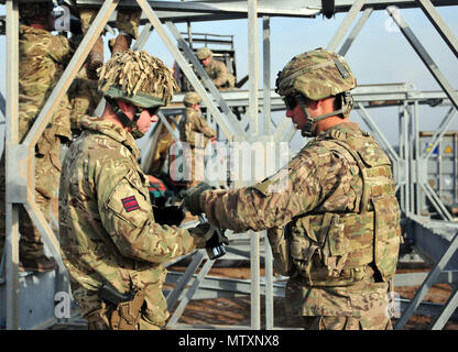 I soldati della 310th multiruolo società Ponte di lavorare al fianco di ingegneri dell'esercito britannico a smantellare un ponte Acrow hanno costruito insieme. Il Acrow ponte costruito aiutato affinare le competenze degli Stati Uniti e gli ingegneri britannici in preparazione al treno esercito iracheno gli ingegneri di ponte a Camp Taji, Iraq, Gennaio 31, 2017. Il 310th MRBC è assegnato all'Ingegnere 153Battaglione, 176Engineer Brigade (Task Force caos). (U.S. Esercito nazionale Guard foto di Capt. Maria Mengrone/rilasciato) Foto Stock