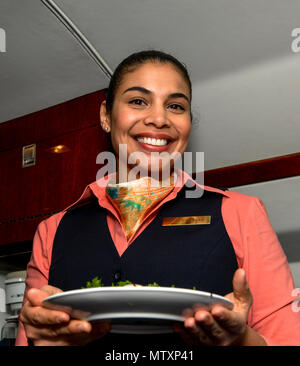 170130-F-WU507-019: Tech. Sgt. Vanessa Schook, 99th Airlift Squadron assistente di volo, si prepara a offrire un pasto crewmates mentre in volo di crociera e a circa 40.000 piedi, mentre si è in volo tra Tallahassee, Florida e Panama City, Panama, Gennaio 27, 2017. FAs sono selettivamente presidiati e assunto da qualsiasi arruolato Air Force Specialty codice per diventare esperti di sicurezza, gli specialisti doganali e artisti culinari. (U.S. Air Force foto di Senior Master Sgt. Kevin Wallace/RILASCIATO) Foto Stock