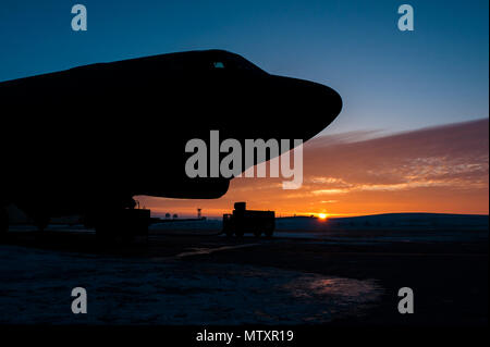 Il sole sorge alle spalle di una B-52H Stratofortress a Minot Air Force Base, N.D., Gennaio 26, 2017. Avieri dal 5 Manutenzione aeromobili squadrone lavorare intorno all'orologio in tutte le condizioni atmosferiche per fornire B-52 firepower on demand. (U.S. Air Force foto/Senior Airman J.T. Armstrong) Foto Stock