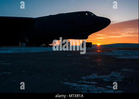 Il sole sorge alle spalle di una B-52H Stratofortress a Minot Air Force Base, N.D., Gennaio 26, 2017. Avieri dal 5 Manutenzione aeromobili squadrone lavorare intorno all'orologio in tutte le condizioni atmosferiche per fornire B-52 firepower on demand. (U.S. Air Force foto/Senior Airman J.T. Armstrong) Foto Stock