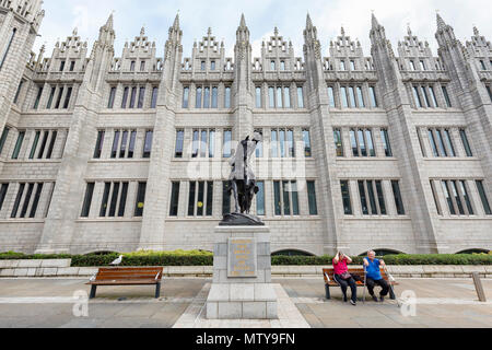 ABERDEEN, Regno Unito - 3 agosto: Unidentified persone sedersi accanto a Robert the Bruce statua che si trova nella parte anteriore del Marischal College nella città di Aberdee Foto Stock