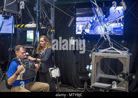 La NASA la realtà virtuale tecnico di laboratorio, Evelyn Miralles prepara astronauta Col. Tyler "Nick" Aia per eseguire una realtà virtuale lo scenario di addestramento per utilizzando la procedura semplificata di aiuti per il salvataggio di EVA (più sicuro) pack durante un emergenza spacewalk per tornare alla Stazione Spaziale Internazionale nella realtà virtuale di laboratorio presso Johnson Space Flight Center a Houston, Tex., apr. 26, 2017. Foto Stock