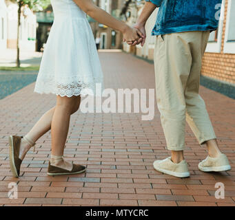 Sezione bassa di giovani alla moda giovane tenendo le mani sulla strada Foto Stock