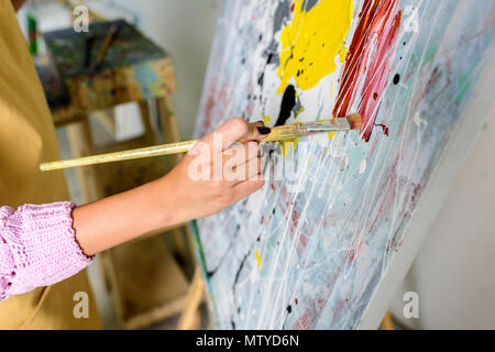 Immagine ritagliata di artista femminile pittura in officina con spazzola di pittura Foto Stock