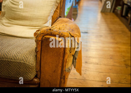 Bistrattato poltrona in pelle in Richard Booth's Cinema Bookshop in Lion Street Hay-on-Wye Foto Stock